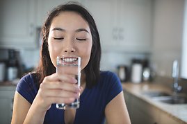Kvinna dricker vatten ur ett glas
